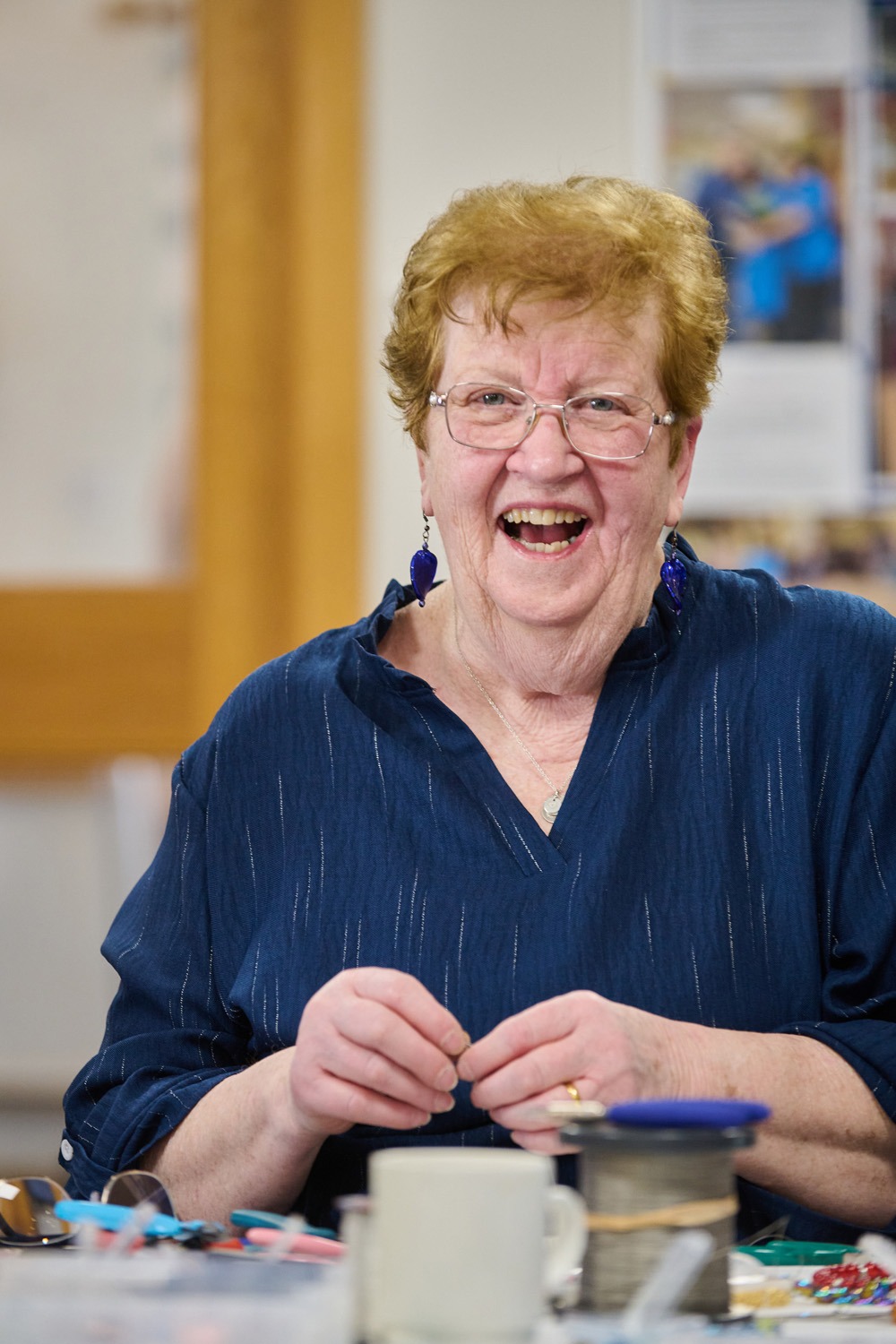 A resident laughing while taking part in a craft activity