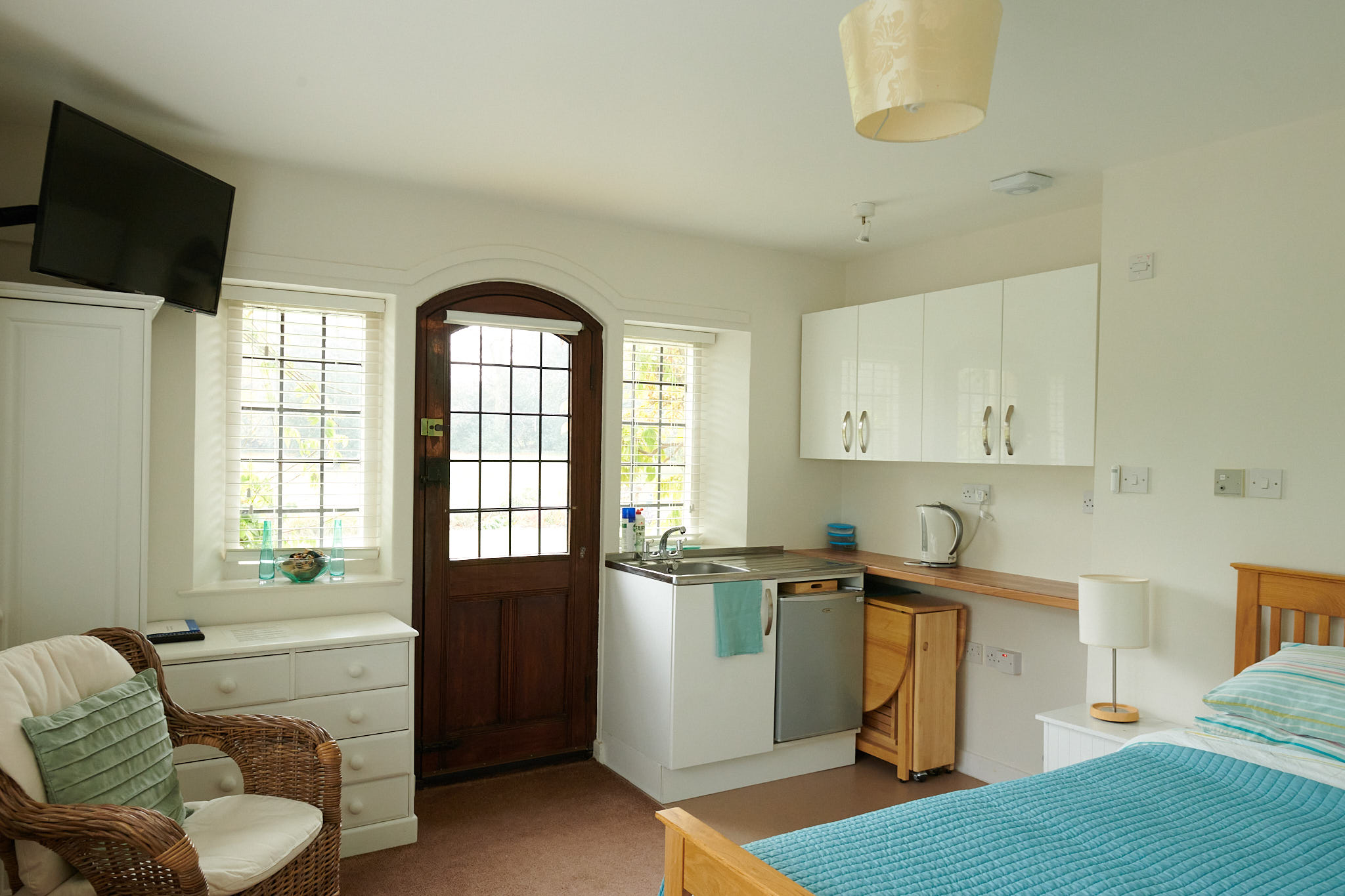 A modern, well-appointed studio room at Weston Acres, with kitchenette, TV and comfortable seating